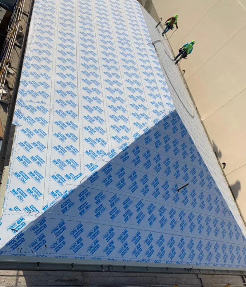 Professional roofers installing underlayment on a metal roof in St. Gabriel